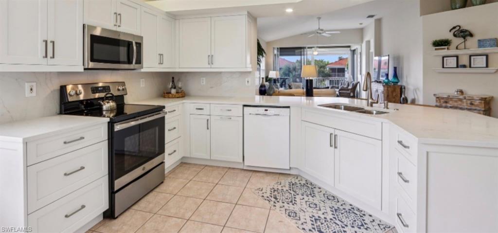 10911 Oak Island Road, Unit 201 Estero, FL 34135 - Photo 5 of 24 a kitchen with white cabinets and appliances