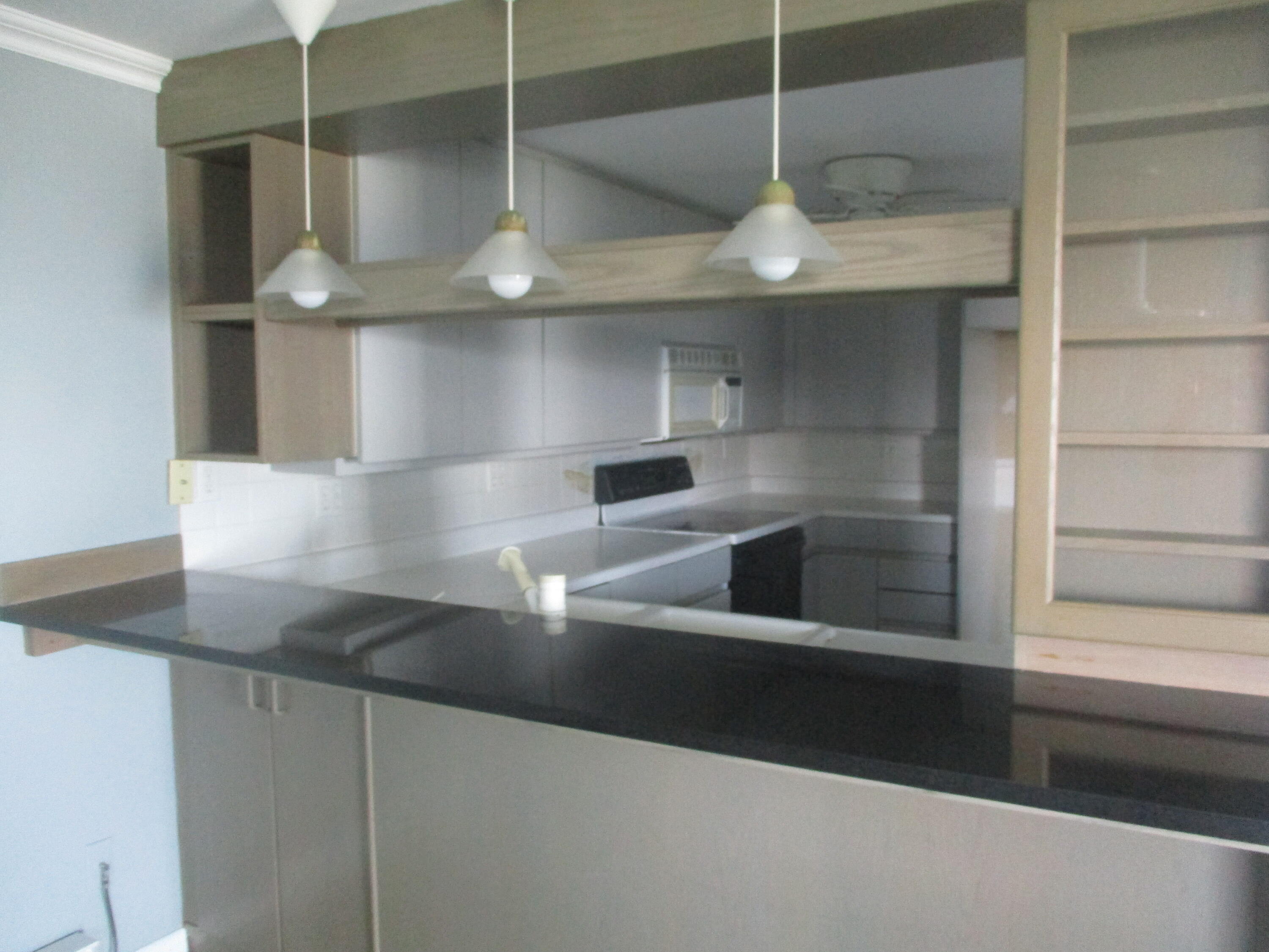 112 Old Wharf Road, Unit E4 Dennis Port, MA 02639 - Photo 8 of 15 a kitchen with kitchen island a large counter top