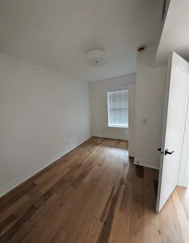 an empty room with wooden floor and window