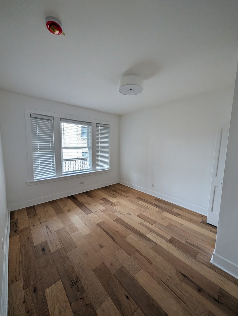 616 West Patterson Avenue, Unit 2E Chicago, IL 60613 - Photo 9 of 18 an empty room with wooden floor and windows