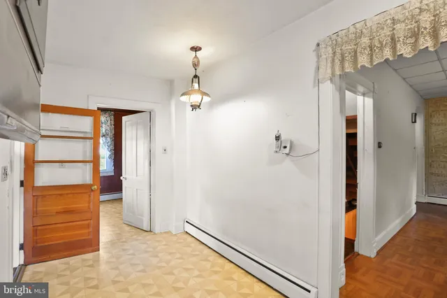 an empty room with wooden floor and window