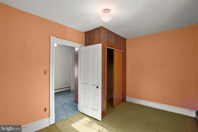 a view of an empty room with a fireplace and a window