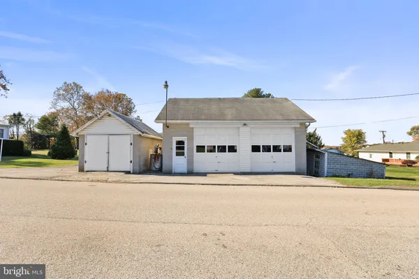 a front view of house with yard and trees in the background