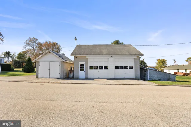 a front view of house with yard and trees in the background