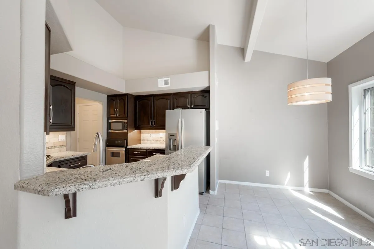 2836 Torrey Pines Road La Jolla, CA 92037 - Photo 11 of 35 a kitchen with stainless steel appliances granite countertop a sink and a refrigerator