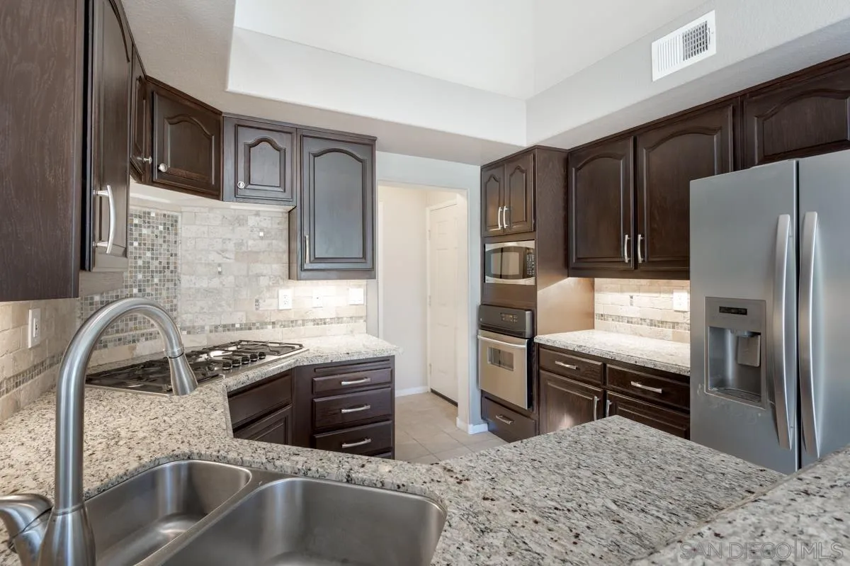 2836 Torrey Pines Road La Jolla, CA 92037 - Photo 14 of 35 a kitchen with stainless steel appliances granite countertop a sink stove and refrigerator