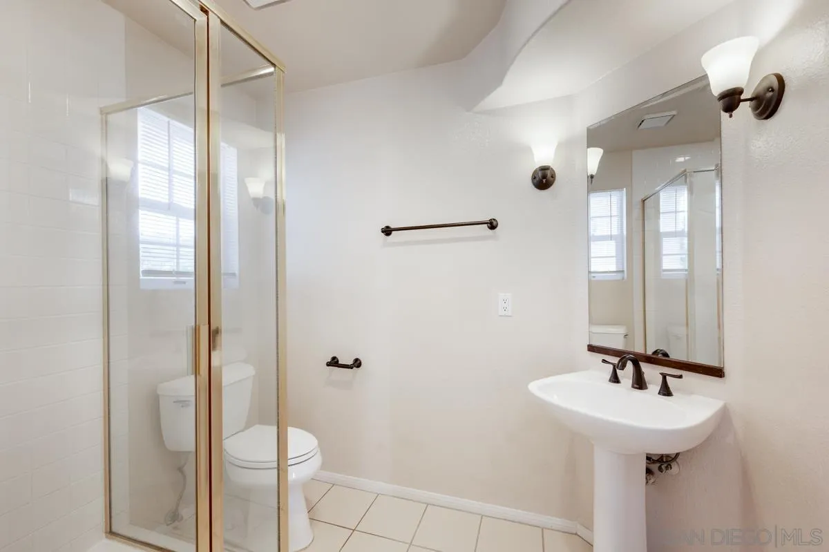 2836 Torrey Pines Road La Jolla, CA 92037 - Photo 29 of 35 a bathroom with a sink a toilet a mirror and shower