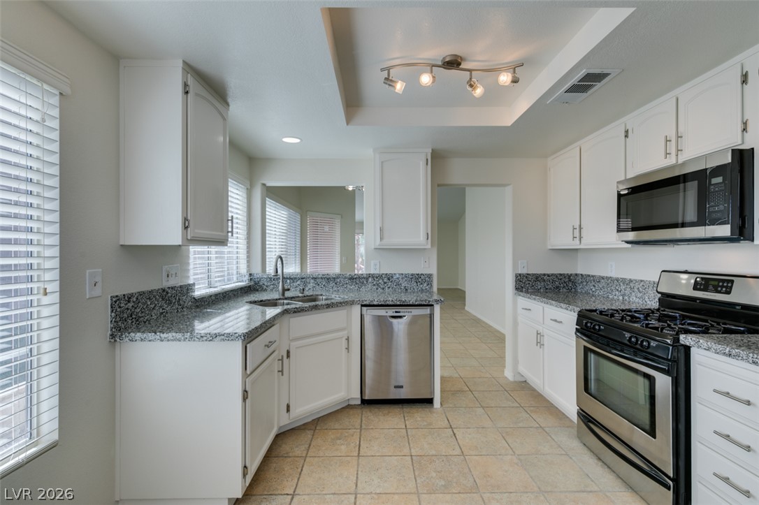 307 Cavalla Street Henderson, NV 89074 - Photo 27 of 44 A well-appointed kitchen features ample counter space, bright cabinetry, and durable tile flooring.