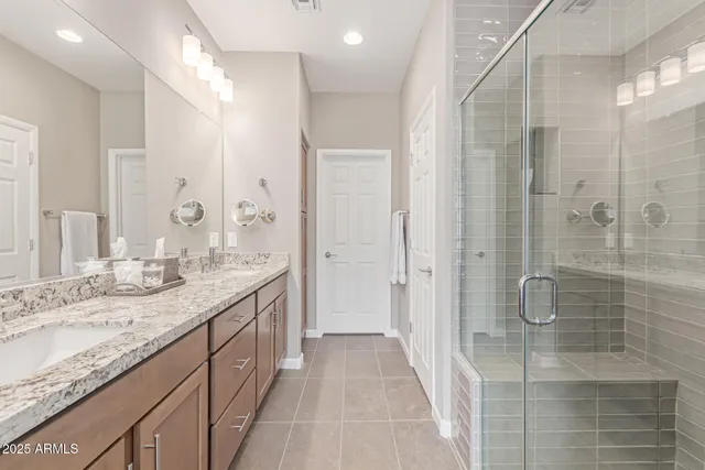 a bathroom with a granite countertop sink mirror and shower