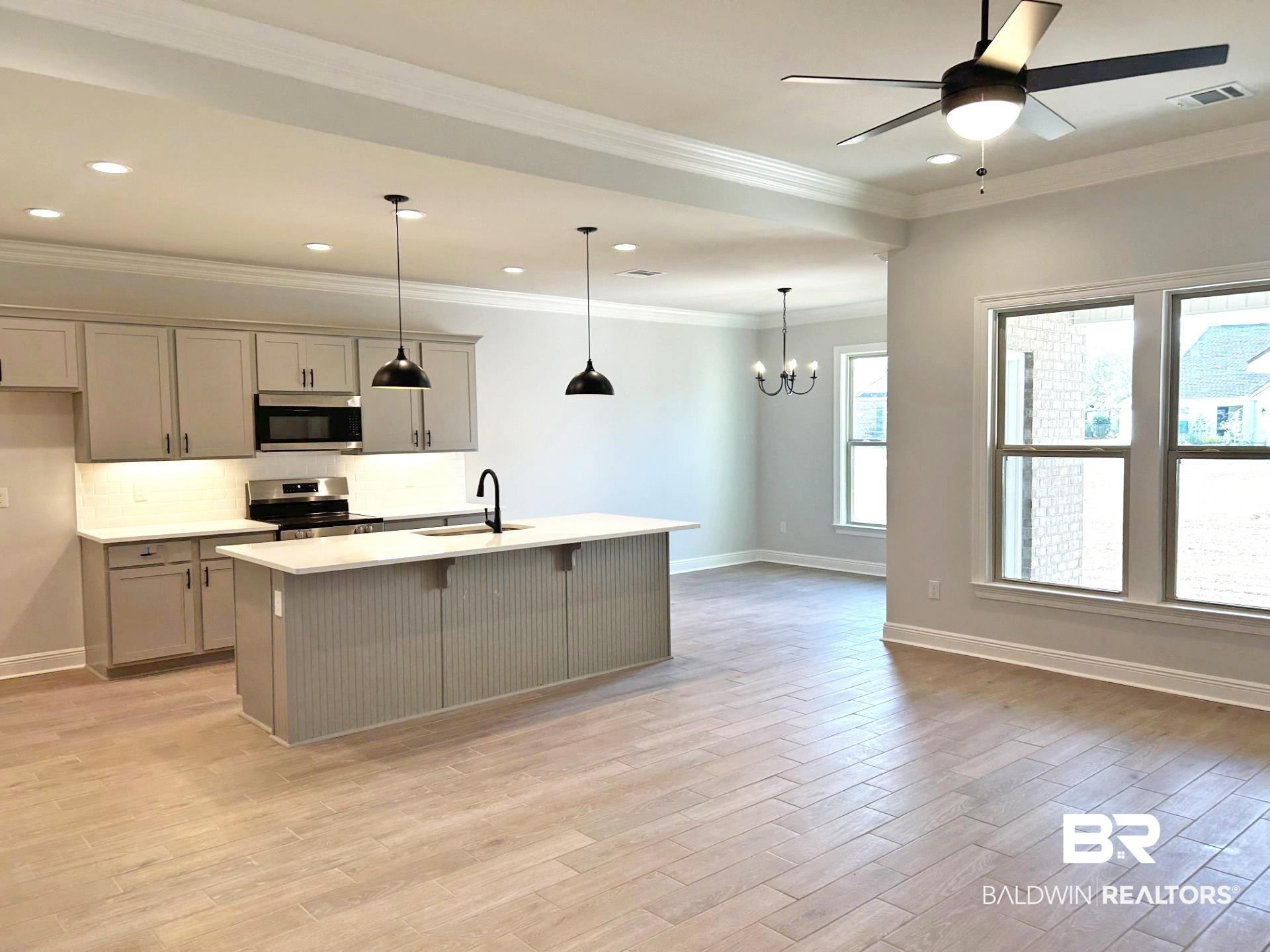 825 Sumter Loop Foley, AL 36535 - Photo 5 of 21 Kitchen featuring gray cabinetry, a kitchen breakfast bar, an island with sink, pendant lighting, and ornamental molding
