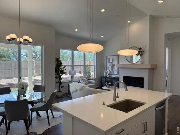 a living room with furniture kitchen view and a chandelier