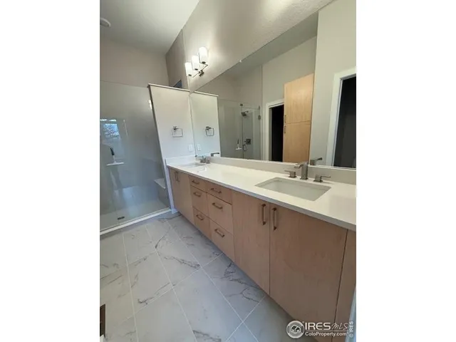 a spacious bathroom with a double vanity sink and mirror