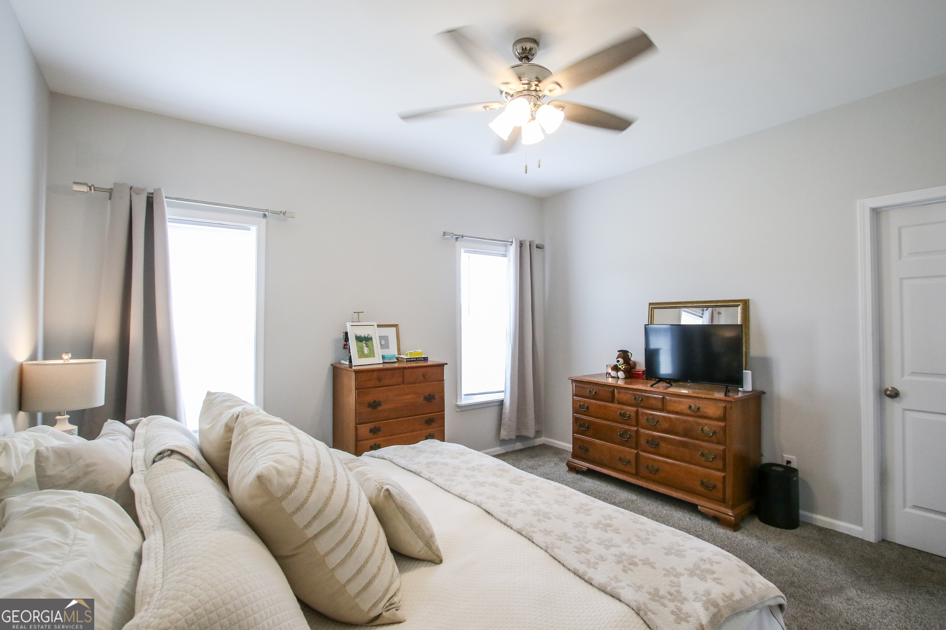 11769 Henry Street Collins, GA 30421 - Photo 42 of 51 a bedroom with a bed and a chandelier
