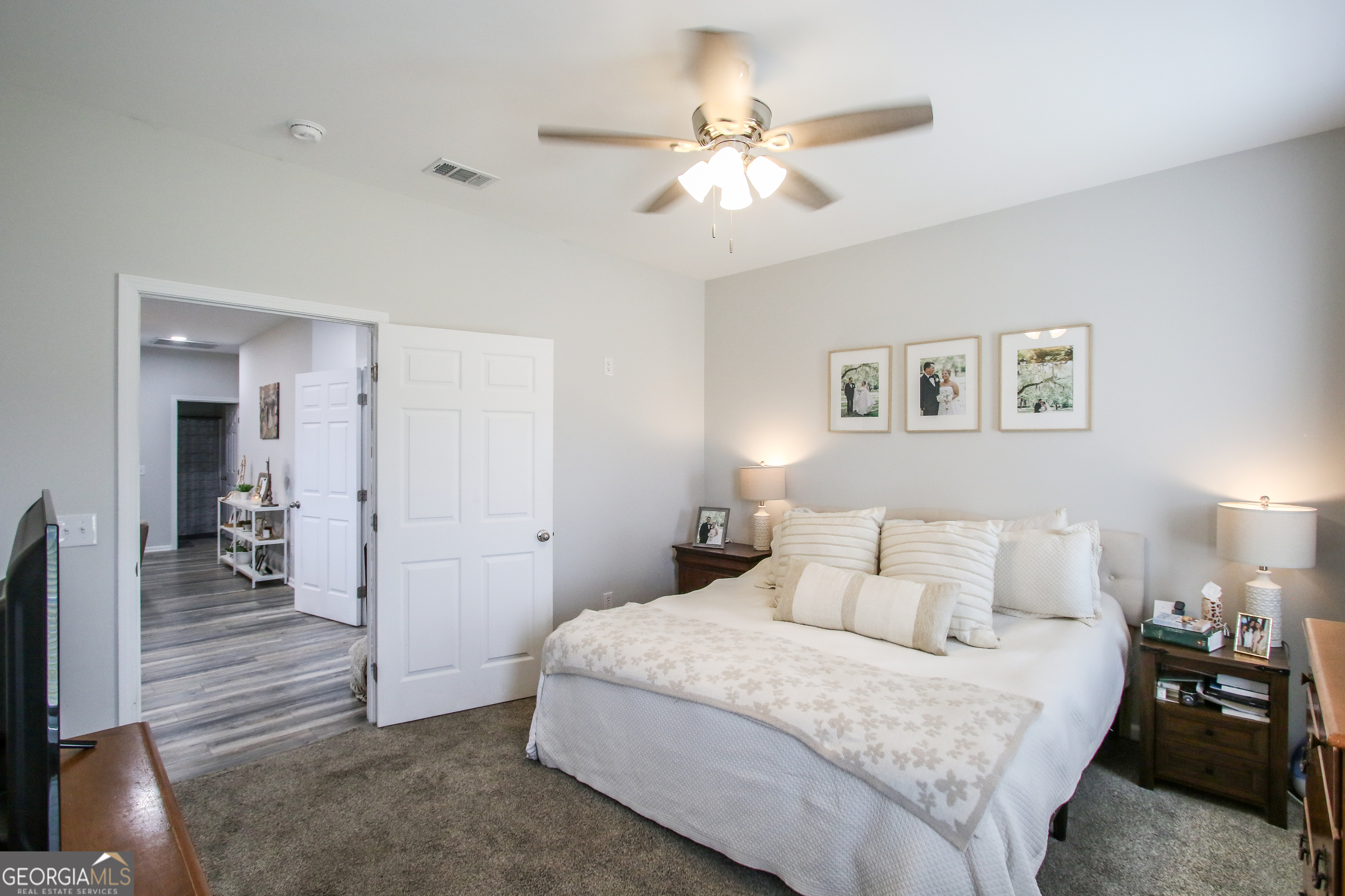 11769 Henry Street Collins, GA 30421 - Photo 43 of 51 a bedroom with a bed and a chandelier