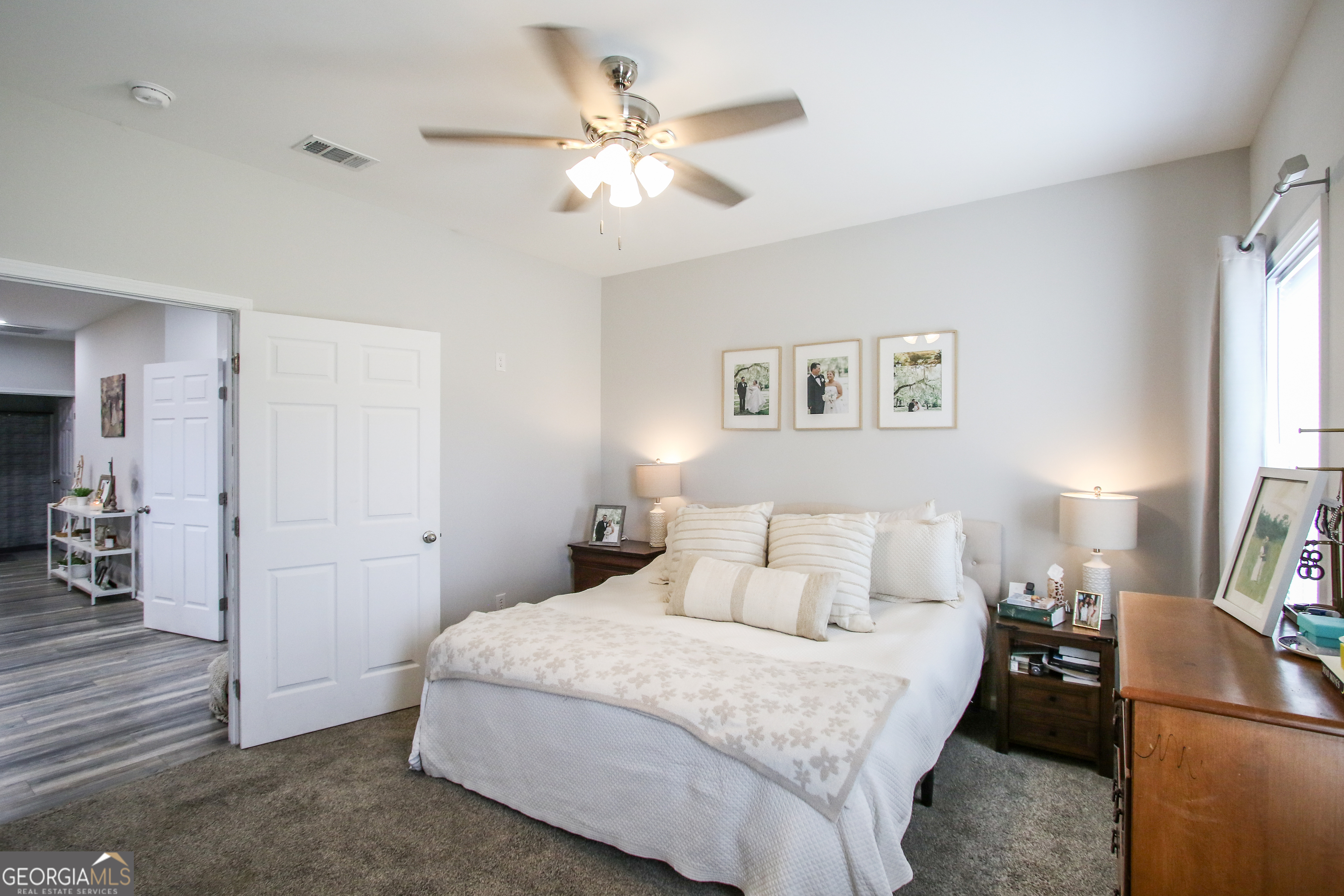 11769 Henry Street Collins, GA 30421 - Photo 44 of 51 a bedroom with a large bed and a chandelier