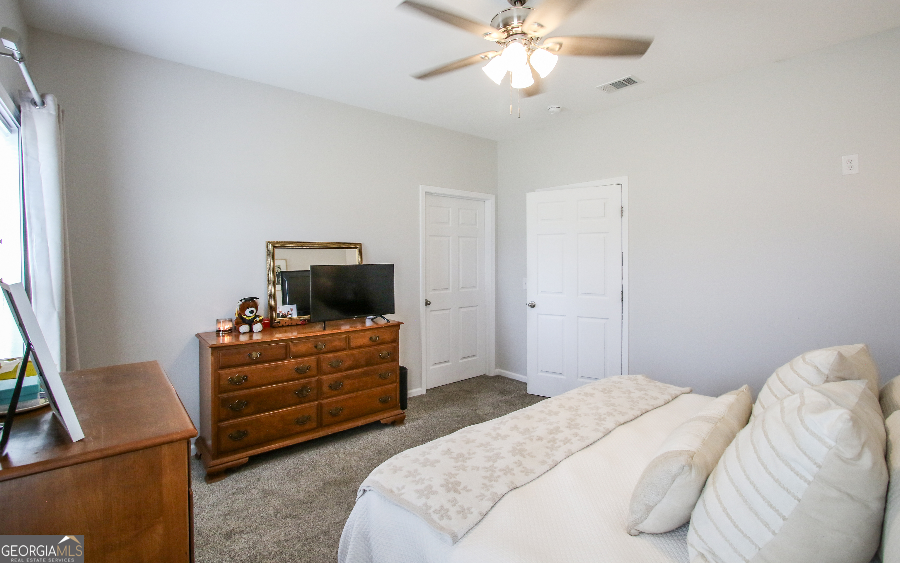 11769 Henry Street Collins, GA 30421 - Photo 45 of 51 a bedroom with a bed and a flat screen tv