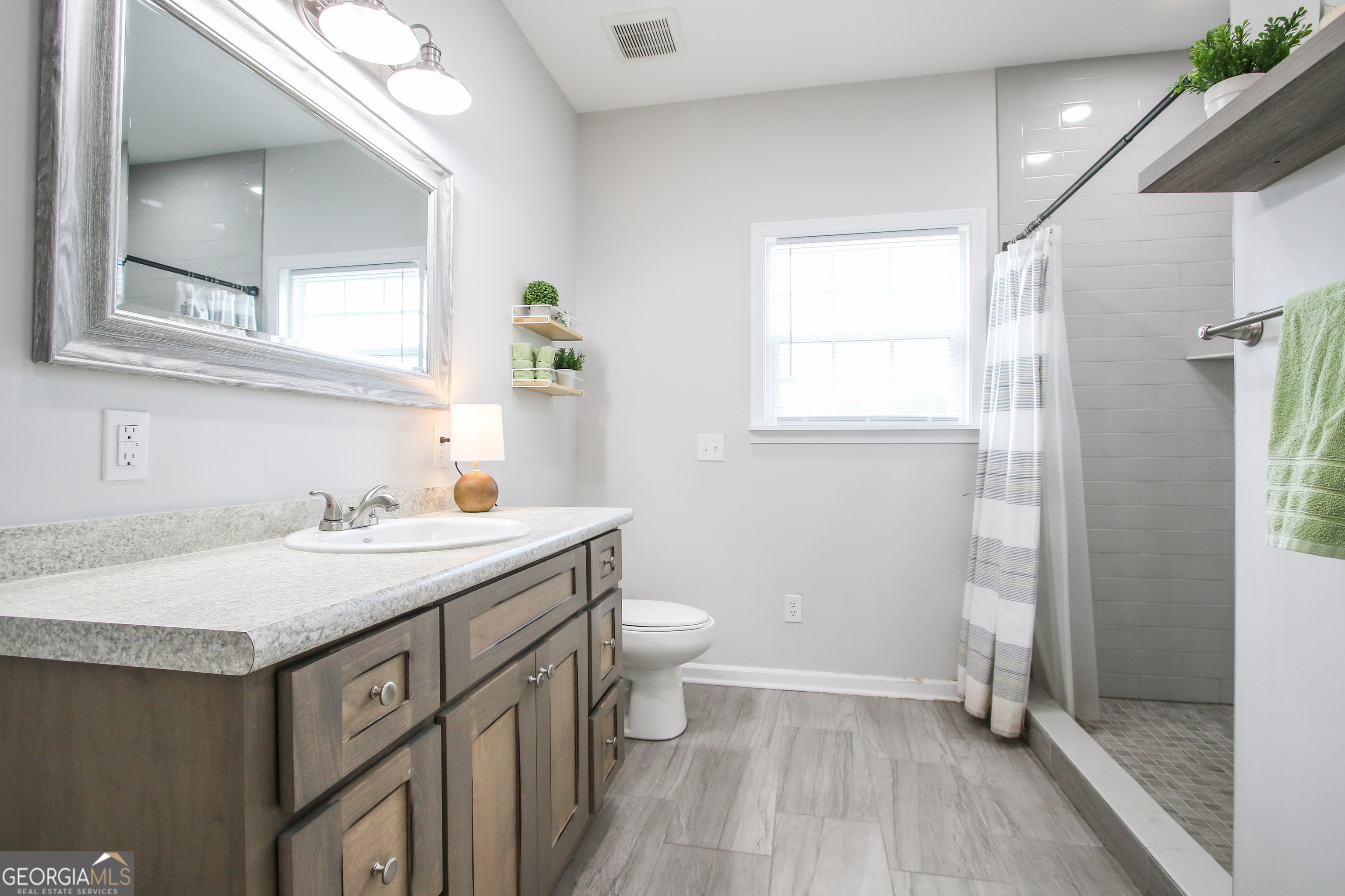 11769 Henry Street Collins, GA 30421 - Photo 49 of 51 a bathroom with a sink a toilet and shower