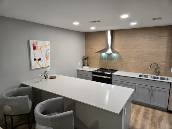 a kitchen with stainless steel appliances a dining table chairs refrigerator and stove