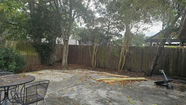 a view of a backyard with wooden fence