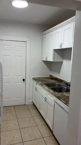 a kitchen with granite countertop a stove a sink and a microwave