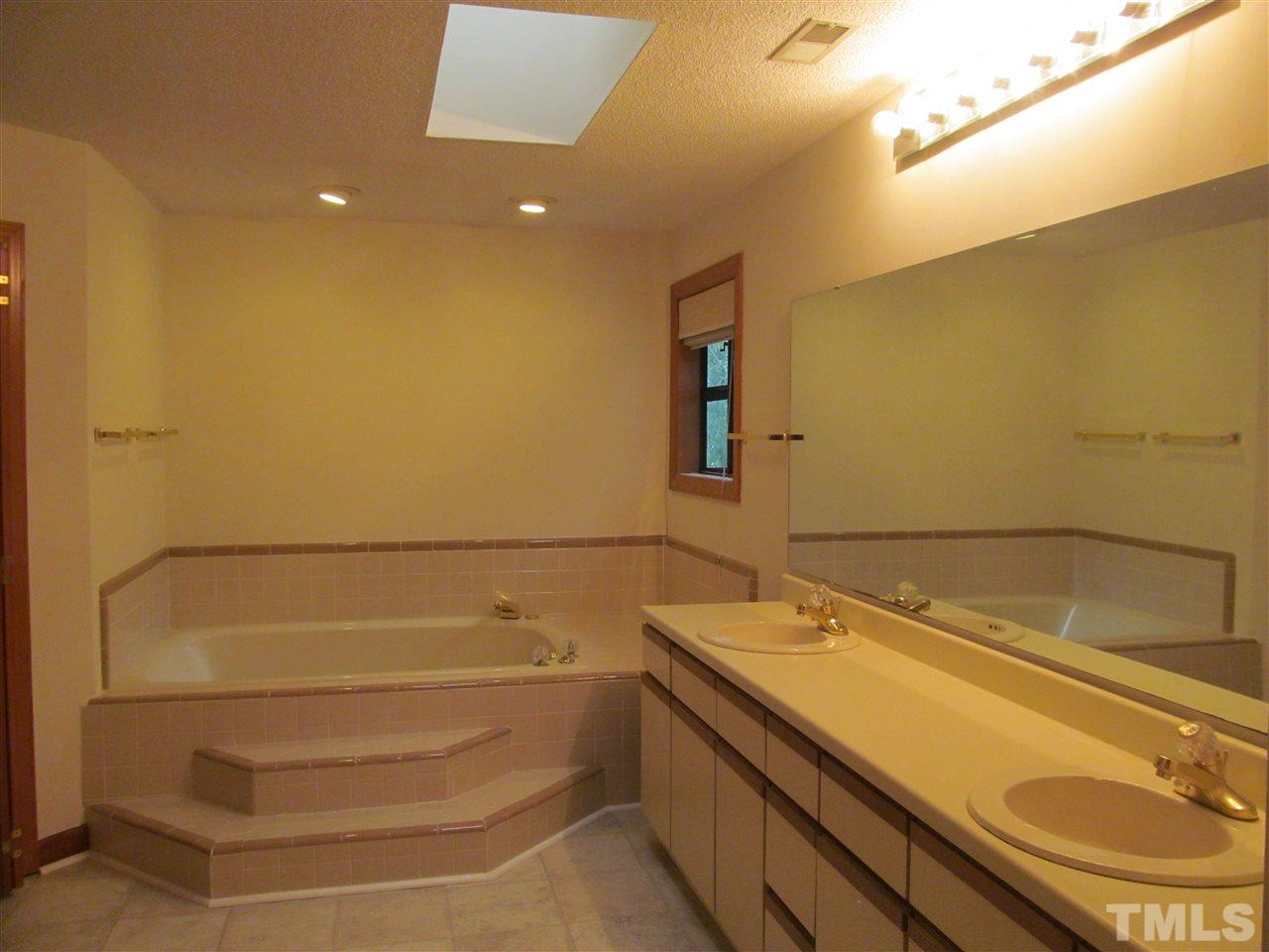 8321 Stryker Court Raleigh, NC 27615 - Photo 8 of 13 a bathroom with a sink and a shower