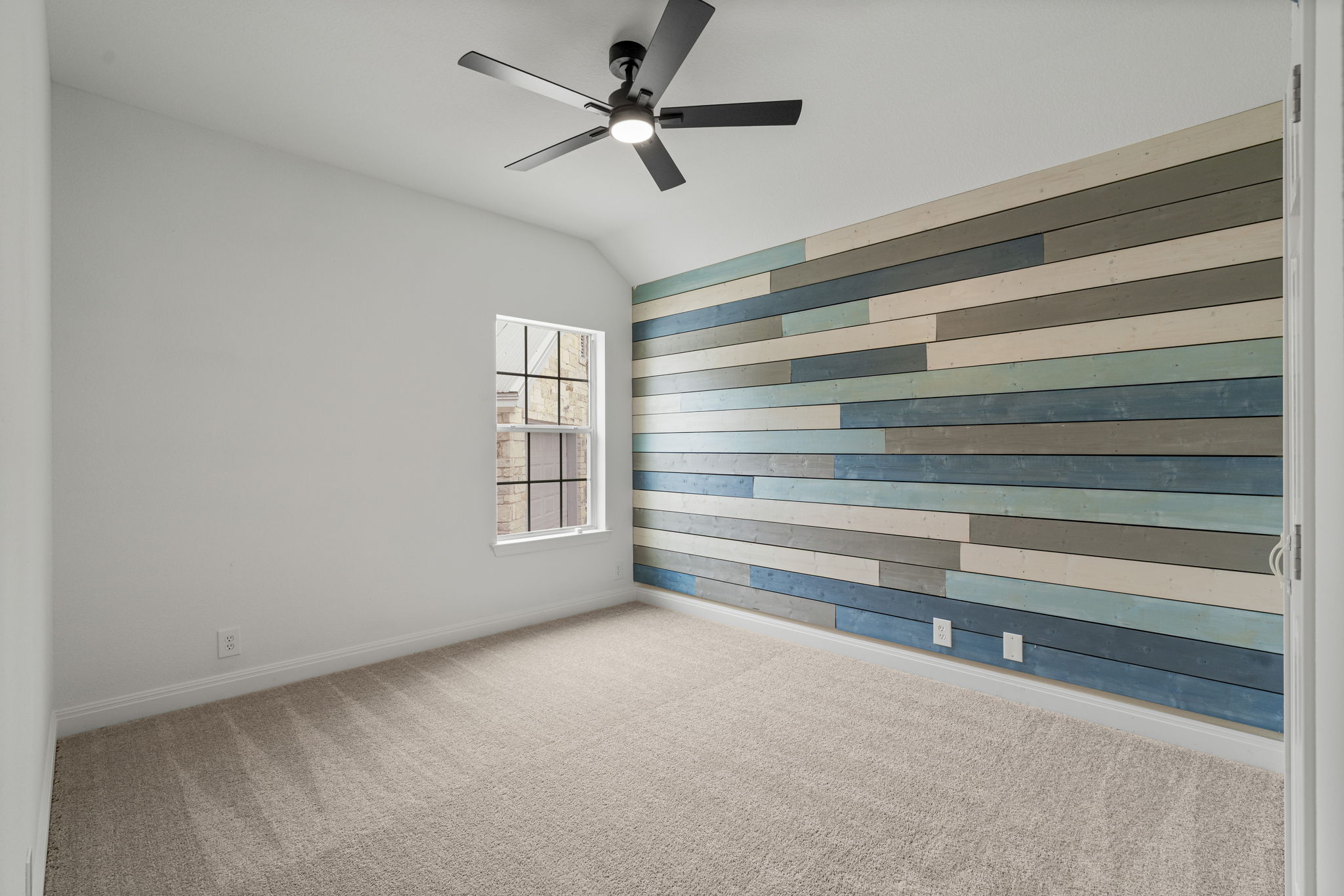 1129 Cedar Pass Road Driftwood, TX 78619 - Photo 25 of 40 The secondary bedrooms aren't just plain boxes! Look at this accent wall with the multi-toned wood planks.