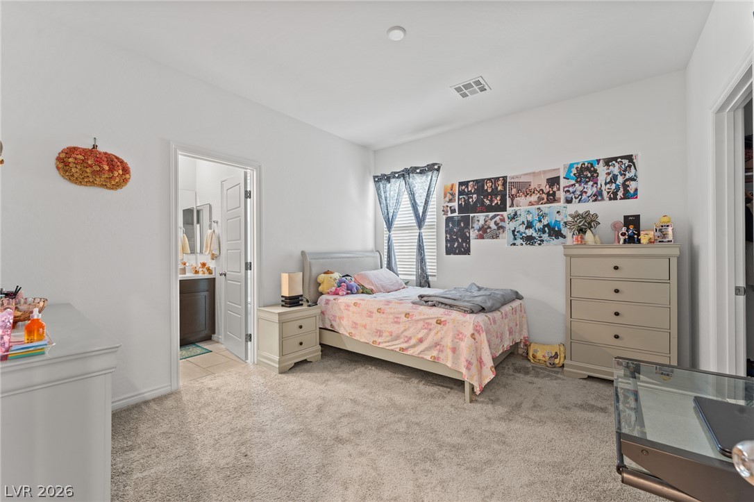 8879 Roadrunner Ravine Street Las Vegas, NV 89166 - Photo 28 of 39 A restful bedroom offers ample floor space, soft carpeting, and a window to let in natural light.