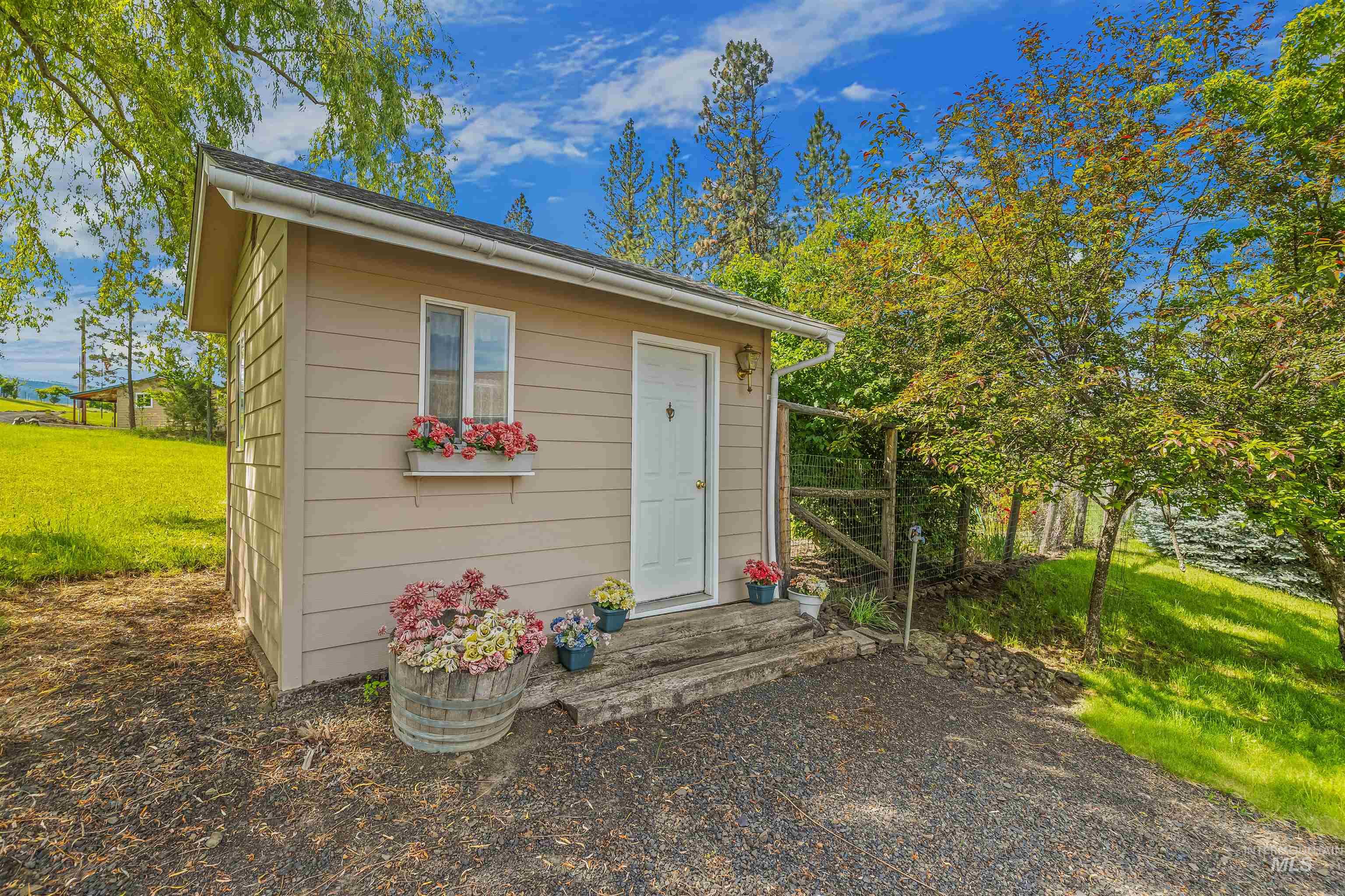 743 Wall Crk Road Stites, ID 83552 - Photo 8 of 48 Exterior structure with horizontal siding, a white entry door, and a white-framed window featuring a flower box
