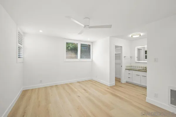 wooden floor in an empty room with a kitchen