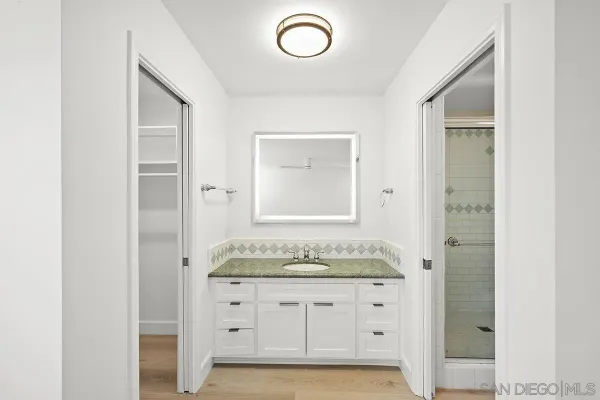 a bathroom with a granite countertop sink and a mirror