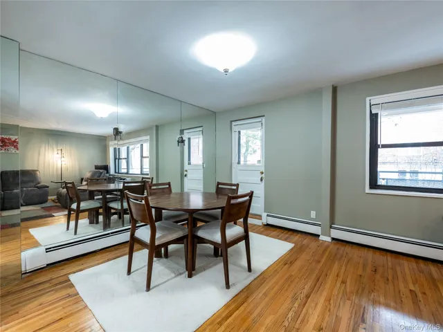 a view of a dining room with furniture a rug and wooden floor