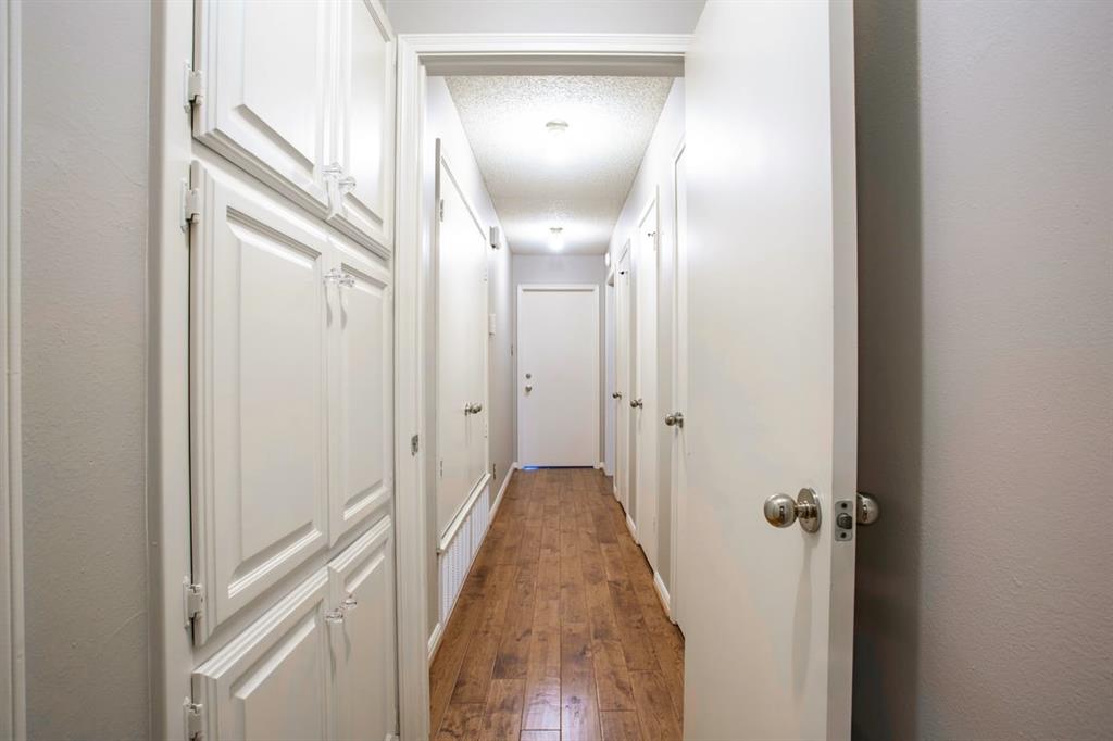 4108 Old Mill Road Waco, TX 76710 - Photo 26 of 40 Ample storage space available in the hallway- a coat closet, two linen closets and linen cabinets available in the hallway with recessed lighting illuminating the wood flooring