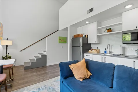 a living room with furniture and a refrigerator