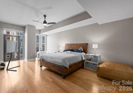 a bedroom with a bed a chandelier and a large window