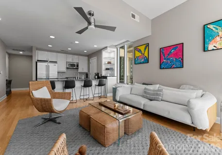 a living room with furniture and a view of kitchen