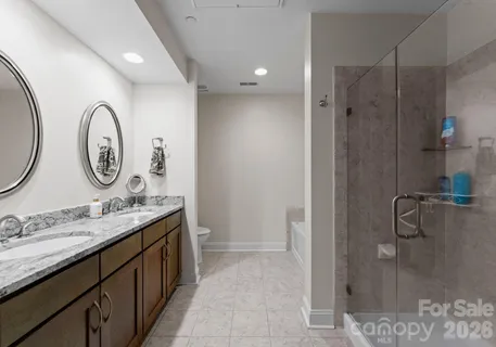 a bathroom with a double vanity sink mirror and shower