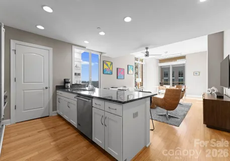 a kitchen with granite countertop a sink and white cabinets