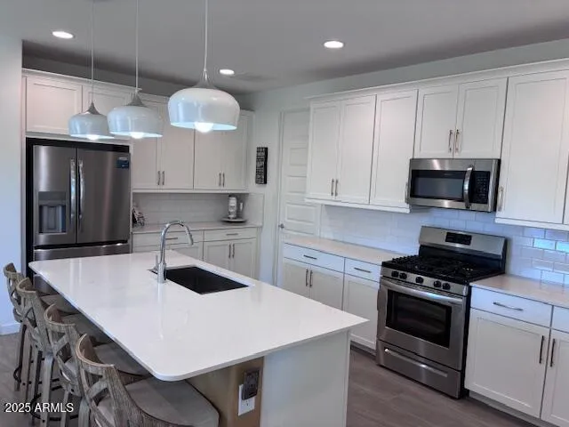 a kitchen with stainless steel appliances a sink a microwave a stove and cabinets