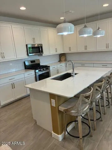 a kitchen with a table chairs microwave and cabinets