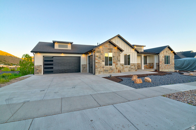 851 Grandview Drive Morgan, UT 84050 - Photo 60 of 68 Modern residential exterior featuring stone veneer, vertical siding accents, and a dark asphalt shingle roof