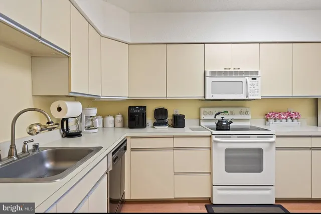 a view of a kitchen with sink a stove and refrigerator