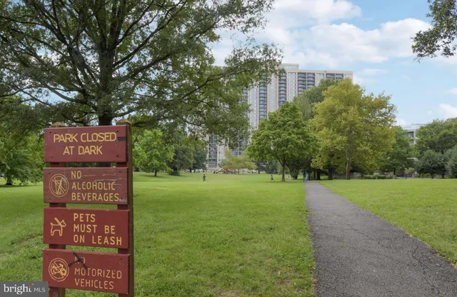 a sign board with a play ground in the back