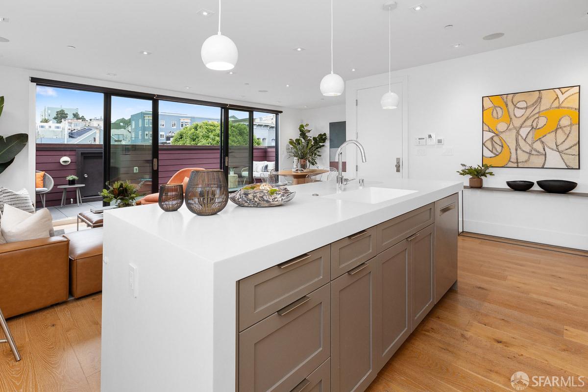 564 Fell Street San Francisco, CA 94102 - Photo 17 of 82 a kitchen with kitchen island a large counter top space a sink a window and a living room view