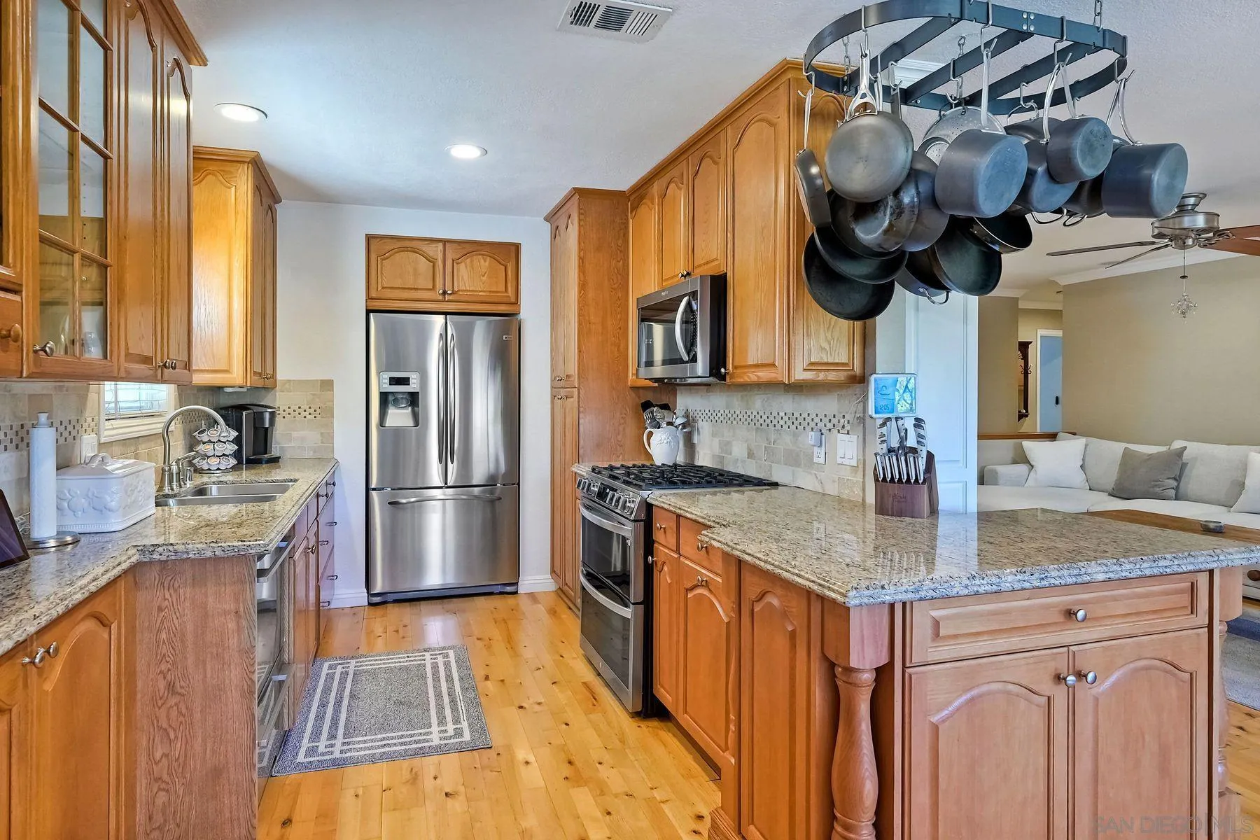 13821 Eisenhower Avenue Poway, CA 92064 - Photo 16 of 37 a kitchen with stainless steel appliances granite countertop a sink a stove and a wooden floors
