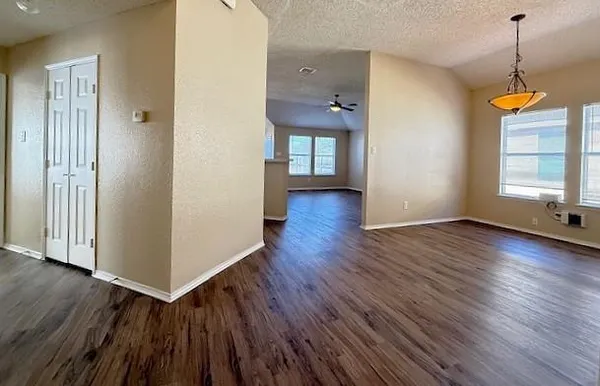 a view of a room with wooden floor and a window
