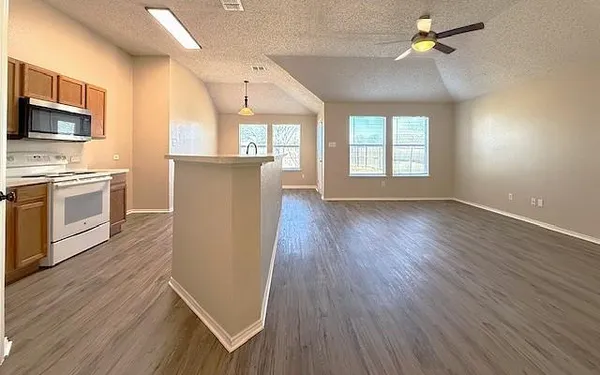 a view of a kitchen with furniture and wooden floor