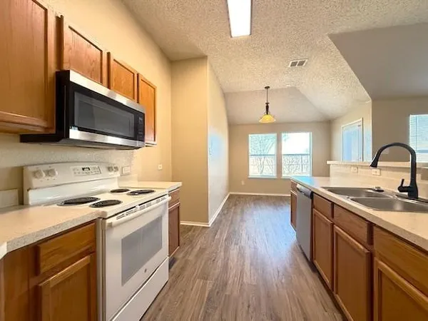 a kitchen with a stove a sink and a microwave