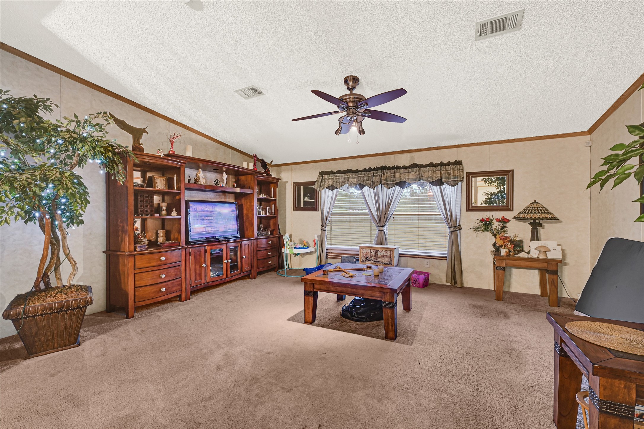 17106 Pickering Road Conroe, TX 77302 - Photo 11 of 50 a living room with furniture a flat screen tv and a large window