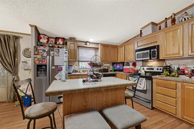 a kitchen with stainless steel appliances granite countertop a stove top oven a sink dishwasher and cabinets with wooden floor