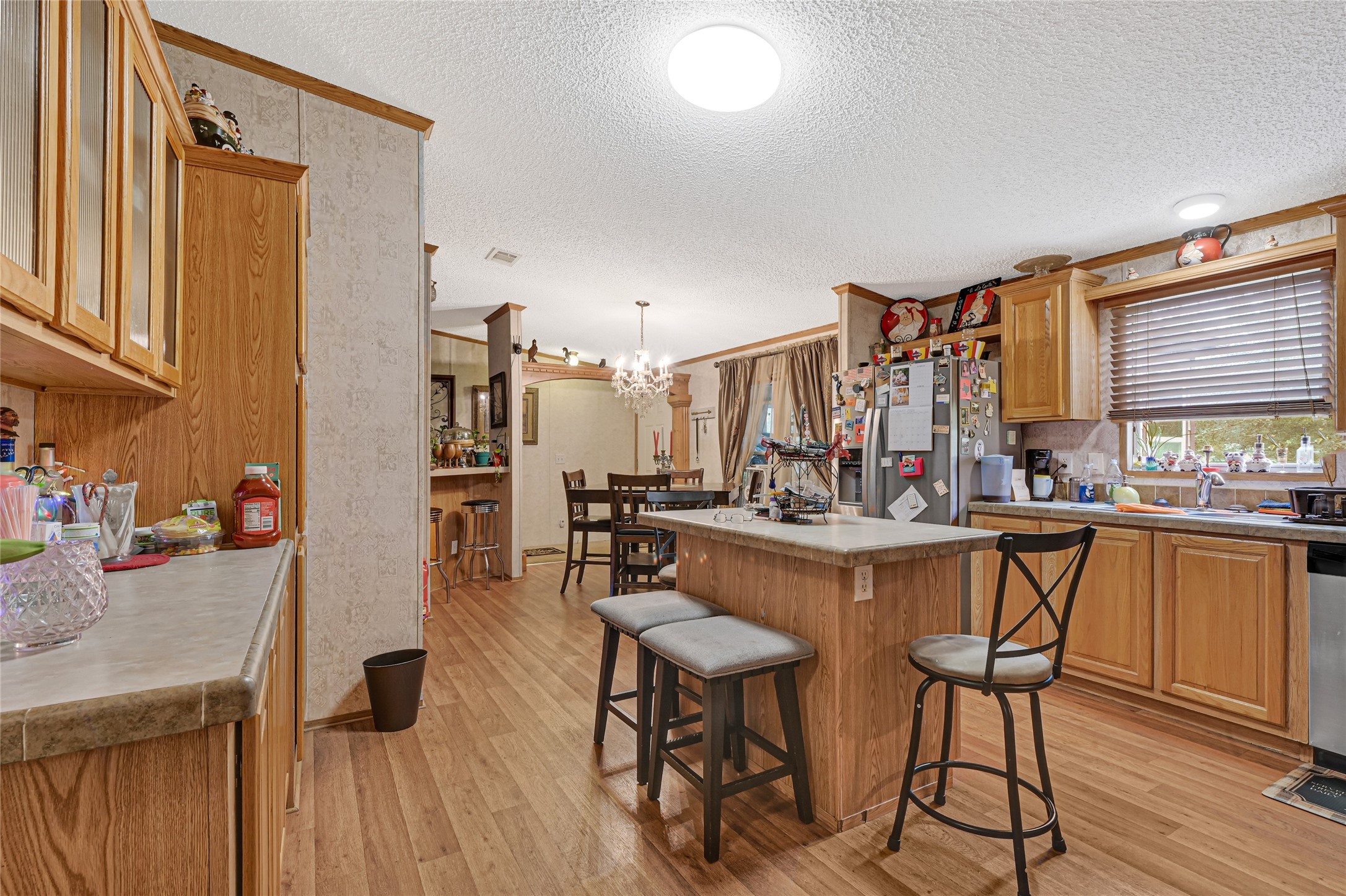 17106 Pickering Road Conroe, TX 77302 - Photo 14 of 50 a kitchen with stainless steel appliances kitchen island granite countertop a table chairs in it and wooden floors